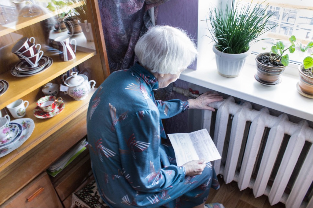 Elderly lady checks radiator