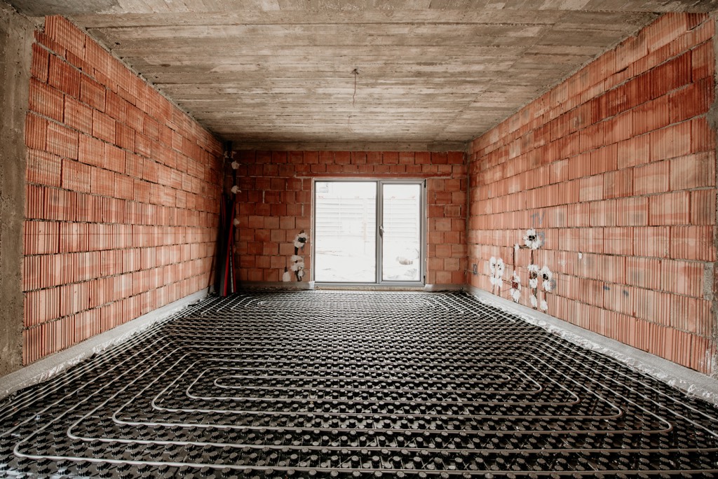 Wet underfloor heating being installed with heat pump